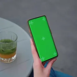 دانلود فوتیج نمای شانه یک زن روی تلفن با صفحه سبز برای موکاپ2